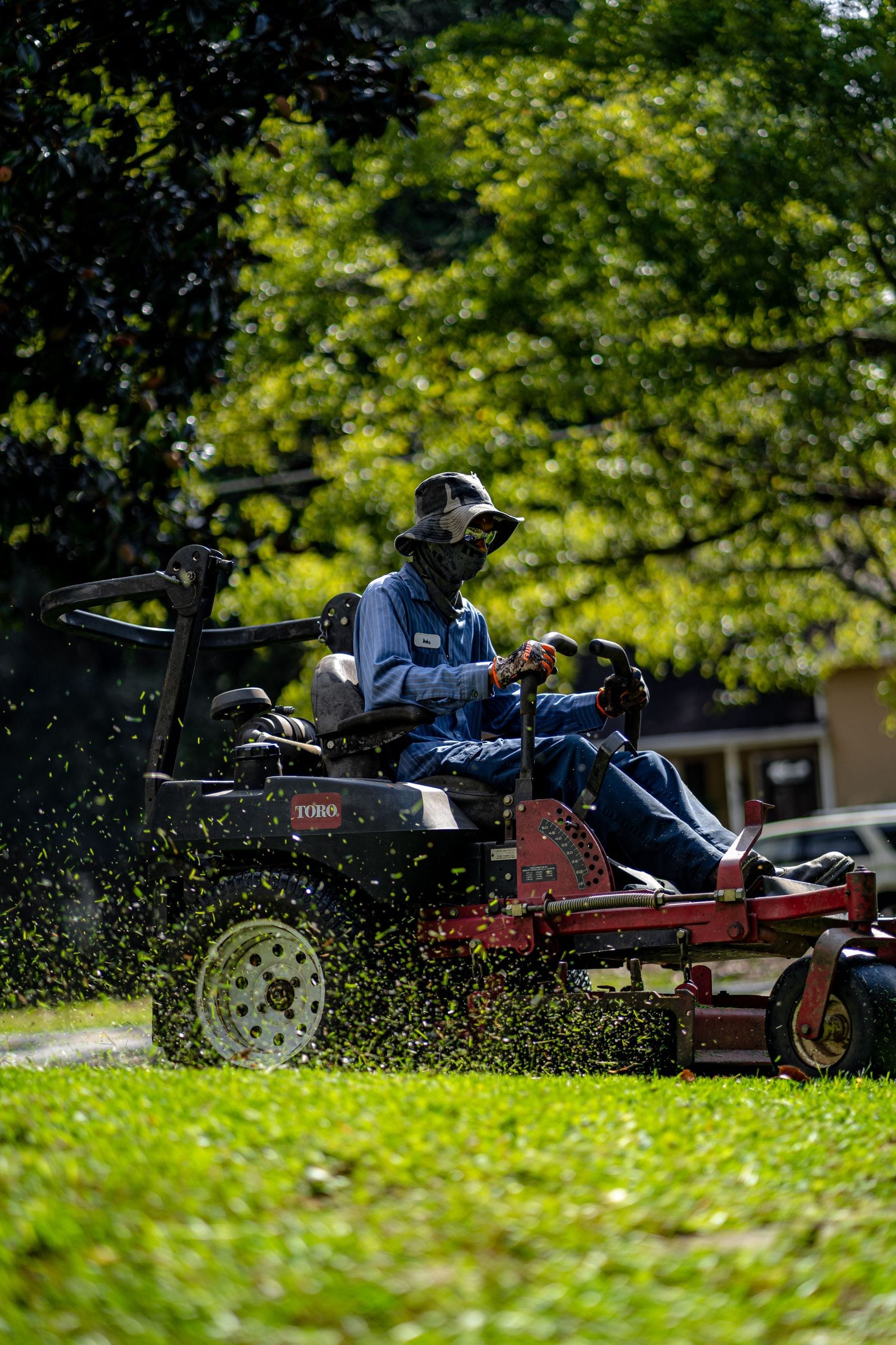 A lawn care professional on a zero-turn mower
